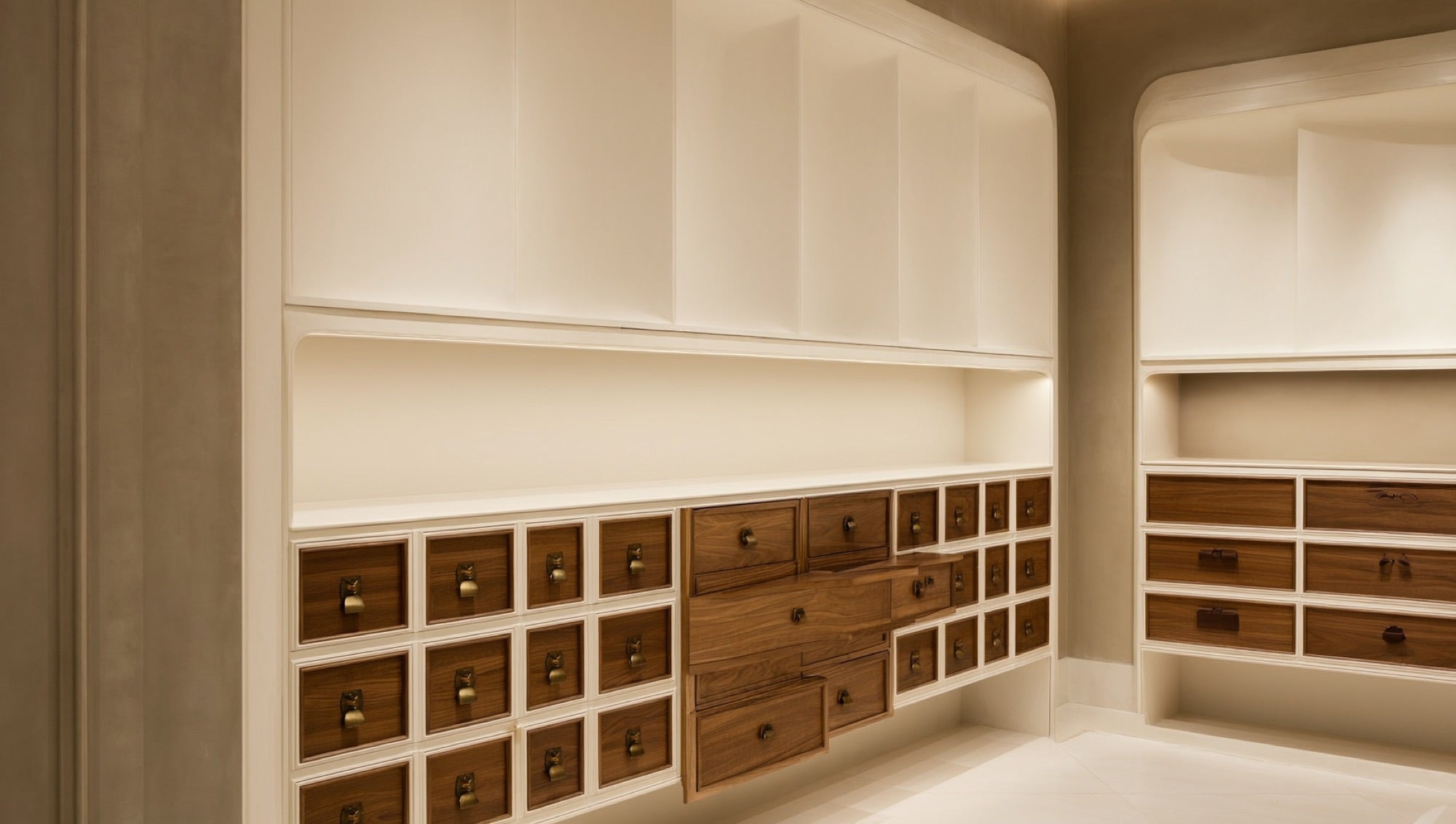 Cabinetry hardware vignette with brass pulls on walnut and cream drawers