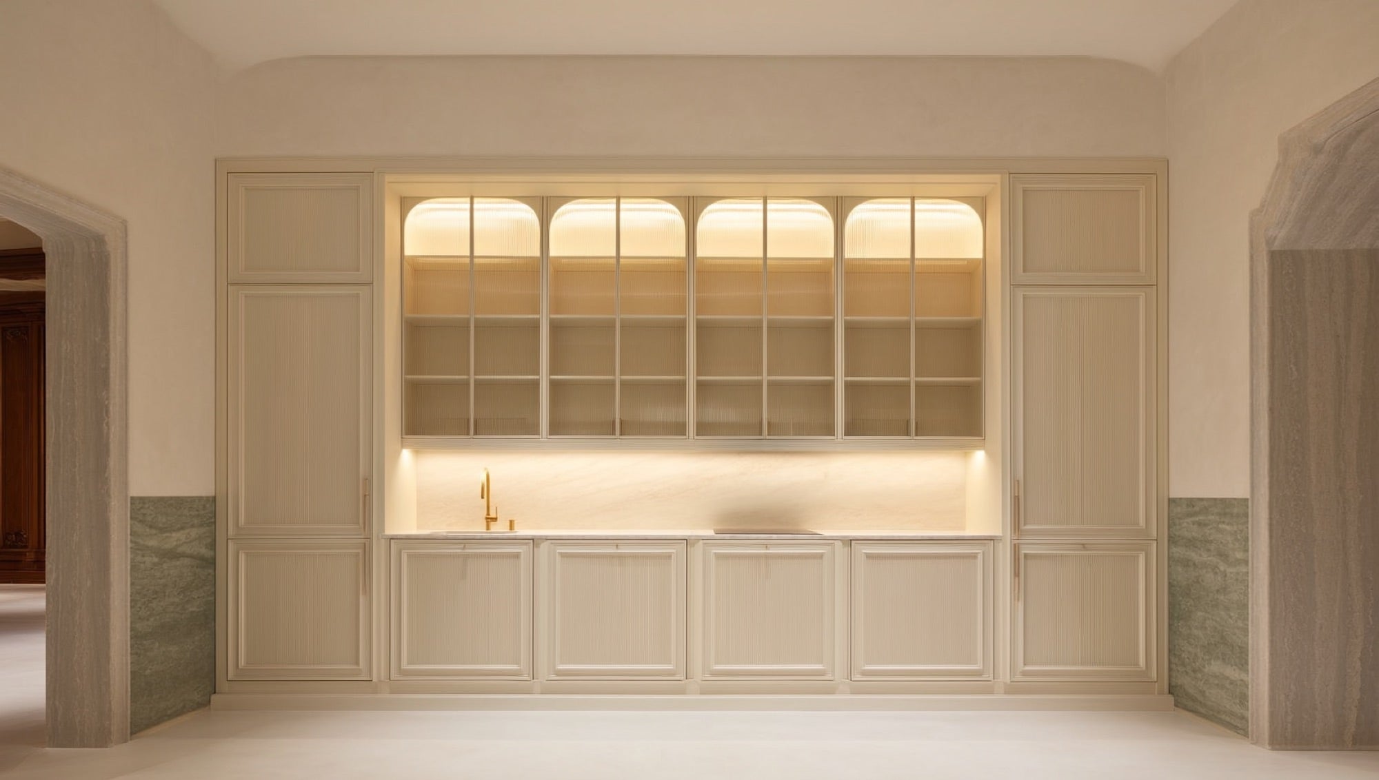 Cream inset-panel luxury kitchen cabinetry with marble backsplash