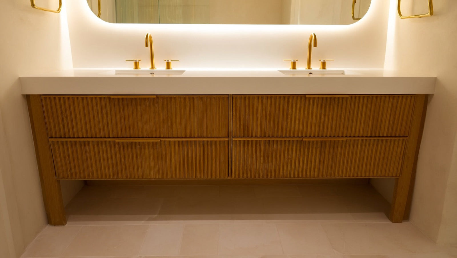 72-inch double vanity in warm white oak with fluted drawer fronts, quartz top and brass hardware