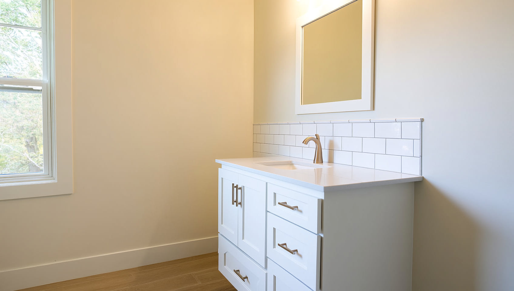 White Shaker single-sink bathroom vanity with a quartz top and framed mirror in a renovated Hackensack, NJ bathroom &mdash; available at ANVE Kitchen & Bath