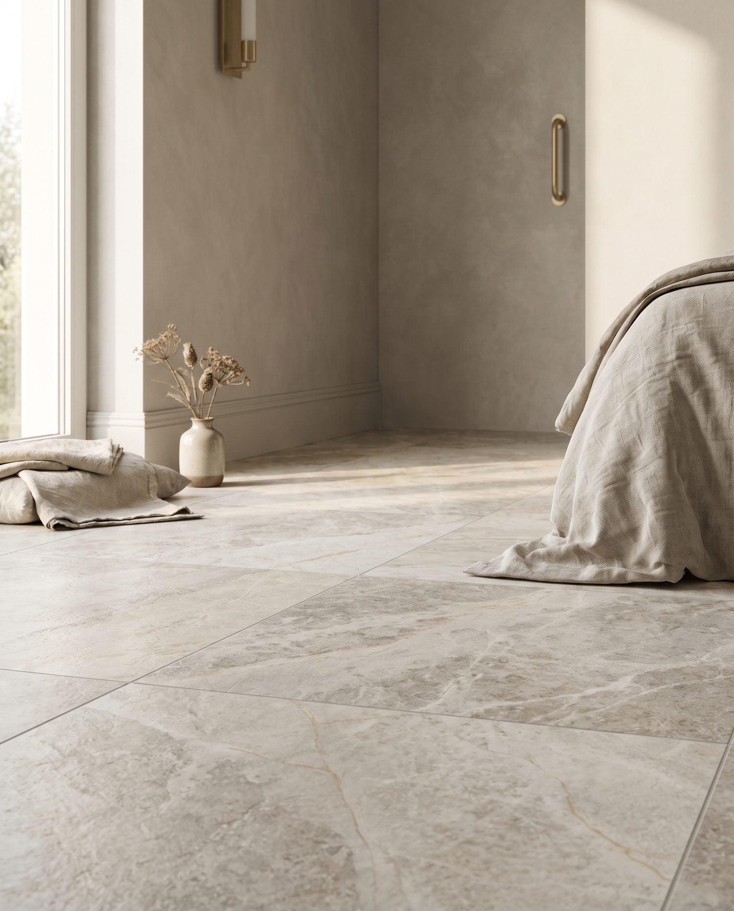A close, raking view of a matte marble-look porcelain entry tile showing its textured surface and pale-gold veining in warm daylight.