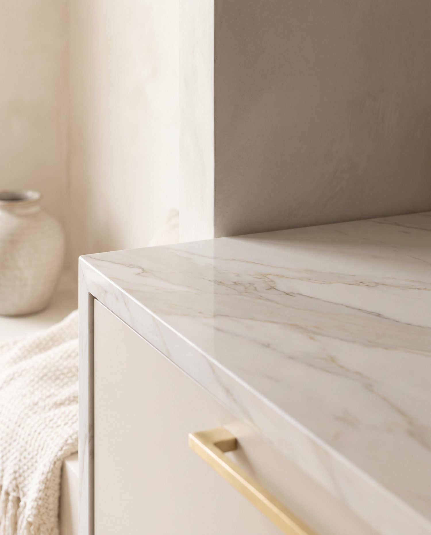 A close detail of large-format marble-look porcelain with soft grey and pale-gold veining for a calm accent wall.