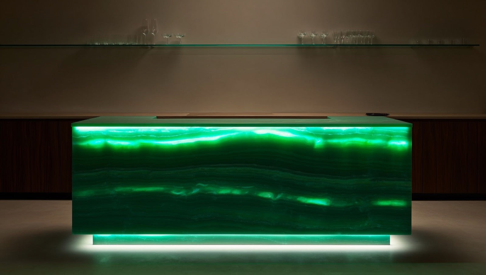 Bar area faced in polished emerald green onyx-look porcelain slab with luminous layered veining, backlit by under-counter lighting against dark walnut cabinetry.