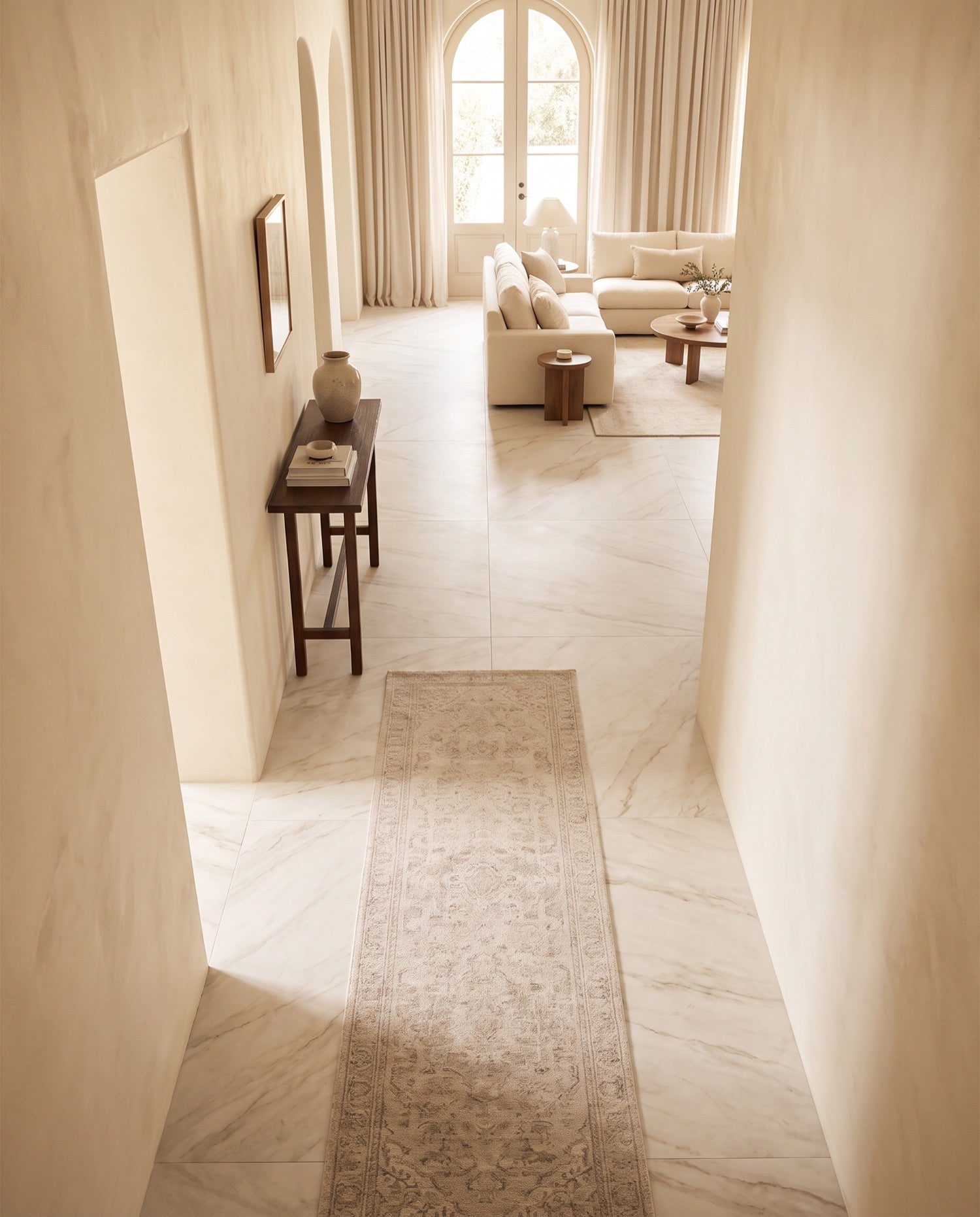 Large-format marble-look porcelain flooring running from a hallway into a bright living room in the ANVE style.