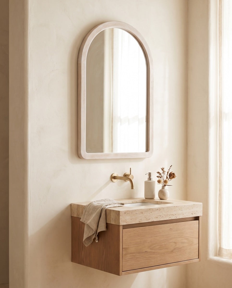 An arched whitewash-oak framed bathroom mirror above a floating vanity in the ANVE Paramus showroom.