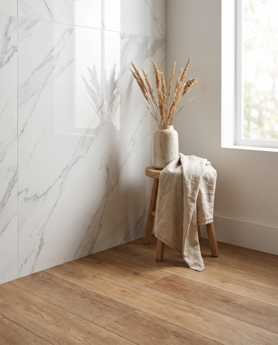 A corner where marble-look porcelain wall tile meets wood-look LVT flooring in the ANVE showroom.