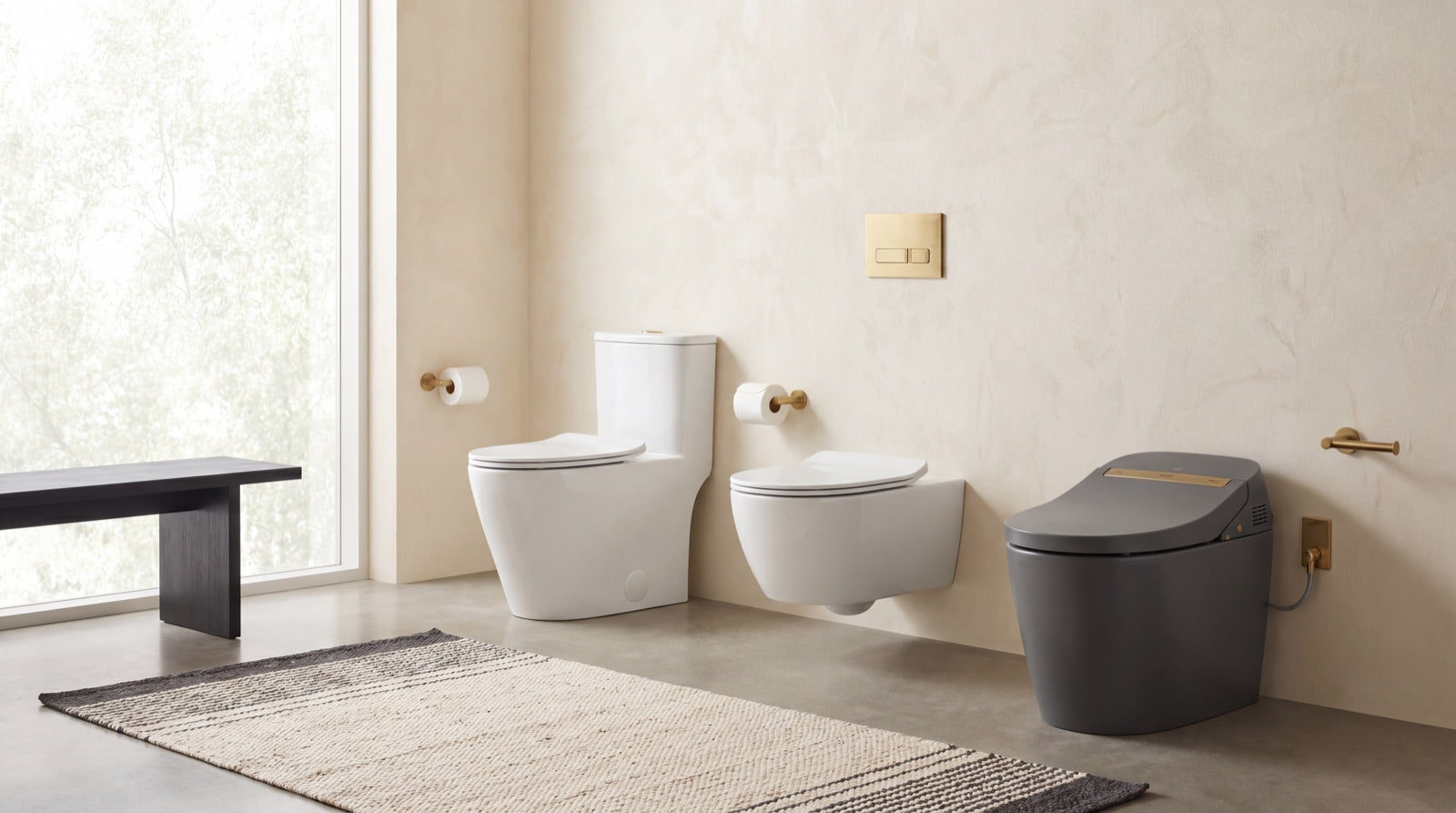 A one-piece white toilet, a wall-hung toilet, and a smart bidet toilet on display in the ANVE Paramus, New Jersey showroom.