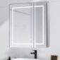 The Royale Plus 30 Inch x 36 Inch LED Lighted Mirror Medicine Cabinet is mounted above a white sink with a black faucet, set against a light-colored wall.