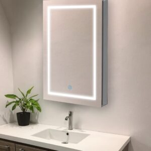 A modern bathroom showcases the Royale Plus 24 Inch x 36 Inch Left Sided LED Lighted Mirror Medicine Cabinet above a white sink and faucet in a wooden vanity, with a small green potted plant on the countertop to the left.