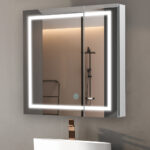 The Royale Plus 36 Inch x 30 Inch LED Lighted Mirror Medicine Cabinet features built-in lighting and a touch sensor, reflecting a minimalist shower area and part of a white sink with a copper faucet.