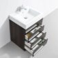 The Barcelona 24 inch Bathroom Vanity Set in Dark Oak features a white rectangular sink with a chrome faucet and three open drawers for towels, toiletries, and storage boxes.