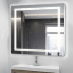 A modern bathroom features the Soho 30 Inch x 30 Inch LED Lighted Bathroom Mirror above a sink and wooden vanity, its edge-lit LEDs glowing as a window reflects a cityscape in the background.