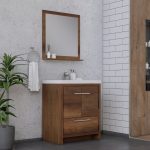 A modern bathroom with a wooden vanity, white countertop, and rectangular mirror. A towel hangs on a ring, and a green potted plant sits nearby. White subway tiles cover part of the wall.