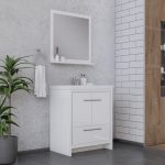 A modern bathroom with a white vanity and square mirror, gray concrete and white tile walls, a potted plant, towel on a ring, and toiletries on the vanity and shelf.