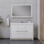 Minimalist bathroom with a large wall mirror above a modern white vanity, a towel hanging on the left, toiletries on the shelf, and a plant in the corner. The walls are a mix of concrete and white shiplap.