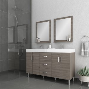 Modern bathroom with gray tile, a glass-enclosed shower, a double-sink vanity with wood cabinets, two rectangular mirrors, silver fixtures, and a potted succulent on the floor. Towels hang on a ring by the vanity.