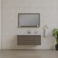 Modern bathroom with beige tiled walls, a large rectangular mirror above a floating wooden vanity, a white sink, minimal toiletries, a towel hanging on a ring, and a green potted plant on the right.