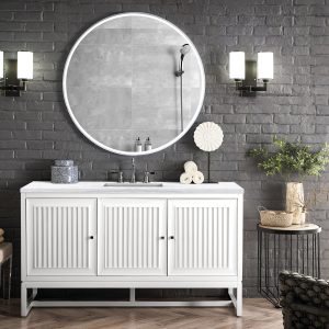 The modern bathroom showcases the Athens 60 Single Bathroom Vanity in Glossy White with a large round mirror above. Two wall-mounted lamps flank it, enhancing the dark brick walls contrast against minimalistic decor. A potted plant and toiletries rest on the countertop, overlooking a city view.