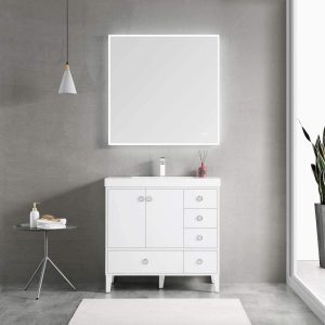 In a minimalist bathroom, the Lyon 36 inch Bathroom Vanity with Acrylic Sink in Matte White is paired with a square LED-lit mirror against grey walls. A small round table sits beneath a pendant light, and a decorative plant in the corner completes the modern decor.