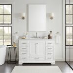 A bright, modern bathroom features the Copenhagen 48 inch Bathroom Vanity with double faucets, a large frameless mirror flanked by two wall sconces, neatly arranged toiletries, black-framed windows, and a tub.