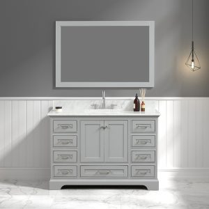 The bathroom features a Copenhagen 48 inch Vanity in Metal Gray with a Carrara marble top, large mirror, and numerous drawers. It holds bottles and a diffuser. A geometric pendant light hangs overhead, while the room is decorated with white wainscoting and gray walls.