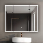 A modern bathroom features a circular white sink, bronze faucet, and the Edge Royal 40 Inch LED Lighted Mirror Medicine Cabinet on a gray wall, reflecting a minimalist room with a window.