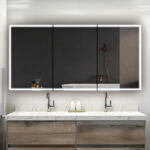 A modern bathroom with a marble countertop, dual sinks, wooden cabinetry, and the Edge Royal 60 Inch LED Lighted Mirror Medicine Cabinet reflecting the bathtub, shelves, and wall-mounted shower. Minimalist decor and neutral tones complete the look.