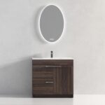 The Hanover 36 inch Bathroom Vanity With Sink includes a dark wood finish, three drawers, a cabinet door, a white countertop, a single faucet, and an oval backlit mirror mounted on a plain light wall.