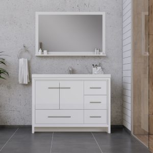 Modern bathroom with a large rectangular mirror above a white vanity with drawers and a sink. Gray tile floor, towel ring with white towel, and concrete and wood-paneled walls are visible. Minimalist décor.