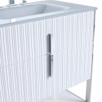 Close-up of a modern bathroom vanity with a white ribbed cabinet front, a sleek chrome handle, and a white sink on top. The vanity has a minimalist design with metal legs.