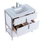 White bathroom vanity with a modern sink, chrome faucet, and metal frame. Two partially open drawers reveal a towel and jars. The sides and front of the vanity have a ribbed texture.