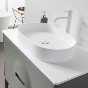 A modern bathroom features an oval white basin, white faucet, gray soap dispenser, and the Colmar 36 inch Olive Green Freestanding Bathroom Vanity set against a minimal white wall.