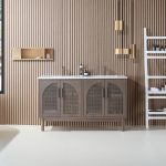 A modern bathroom features the Nara 60 inch Chestnut Oak Freestanding Bathroom Vanity, arched cabinet doors, a slatted wood wall, gold pendant lights, a white ladder shelf for toiletries and towels, and a small wall-mounted shelf.