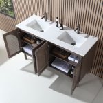 A Nara 60 inch Chestnut Oak Freestanding Bathroom Vanity stands against a striped wooden wall, its open cabinet doors showing folded towels and organized toiletries neatly placed on the shelves.