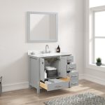The Geneva 36 inch Bathroom Vanity in Metal Gray features a Carrara marble countertop, silver faucet, mirror, and sleek drawers. Open storage holds baskets and towels, while a soap dispenser and small plant decorate the surface.