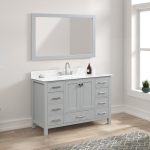 The Geneva 48 inch Bathroom Vanity in Metal Gray features a Carrara marble countertop, under-mount sink, chrome faucet, and a large rectangular mirror. A soap dispenser, window, and small plant nearby add a fresh touch.