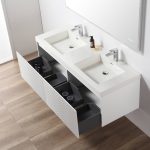 The Positano 60 inch Double Sink Wall Mount Bathroom Vanity in Matte White with Acrylic Top features two rectangular sinks and organized drawers, set above a light wood floor and beneath a large mirror.