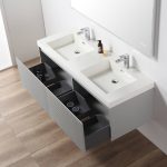 The Positano 60 inch Double Wall Mount Bathroom Vanity in Light Gray with Acrylic Top features dual sinks and offers modern style, mounted below a large mirror on a light wood floor, creating a sleek bathroom centerpiece.