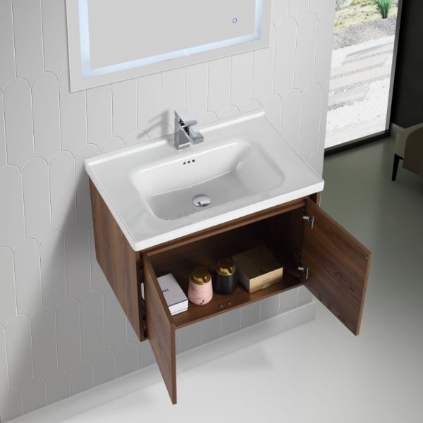 This modern bathroom features the Bern 32 Wall Mount Vanity in brown walnut with a square sink. The elegant wooden cabinet opens to reveal storage space with a pink container, brown jar, and small white box. Curved tile patterns adorn the walls, enhancing the natural light from the large window.