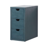 A small blue wooden cabinet with three drawers, each with a half-moon cut-out handle, echoing the classic style of the Shawbridge 60 inch Modern Bathroom Vanity, set against a plain white background.