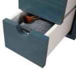 A close-up of an open drawer in the Shawbridge 60 inch Modern Bathroom Vanity shows a blue front, a folded gray towel, and a wooden-handled makeup brush. A partially visible upper drawer is seen above.