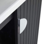 A close-up of a cabinet with vertical grooves, a shiny heart-shaped chrome handle, and part of a white countertop above, from the elegant Venezian 24 inch Bathroom Vanity With Sink.