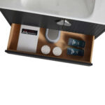 Open the drawer of the Venezian 30 inch Bathroom Vanity With Sink to reveal two round white textured items, a booklet, and two dark-labeled bottles, all neatly arranged around the sink plumbing.