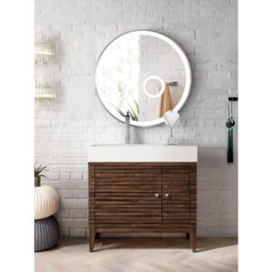 A modern bathroom features a round backlit mirror above the Linear 36 inch Bathroom Vanity Cabinet with a white countertop. White brick walls and decorative accents like a lamp and hanging ornaments complete the look.