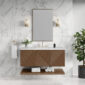 Modern bathroom with white marble walls, a rectangular mirror, wall-mounted lights, and a Marcello 48 inch Wall Mounted Vanity in Chestnut featuring geometric doors, a white sink, and a plant on the right. Towels and toiletries are neatly arranged.