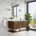 Modern bathroom with a floating wooden vanity, geometric pattern, and gold fixtures. Marble walls, a large mirror, wall sconces, a potted plant, and folded towels complete the decor. Large window lets in natural light.