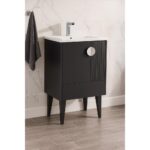 The Venezian 24 inch Bathroom Vanity With Sink in black features tapered legs, a white sink, and a sleek faucet, complemented by a gray towel. White marble tile walls and wood-look floor tiles create a stylish bathroom backdrop.