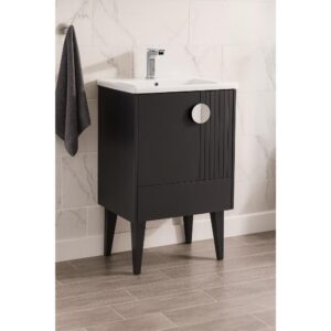 The Venezian 24 inch Bathroom Vanity With Sink in black features tapered legs, a white sink, and a sleek faucet, complemented by a gray towel. White marble tile walls and wood-look floor tiles create a stylish bathroom backdrop.