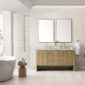 A modern bathroom showcases a Hudson 60 inch Double Vanity Cabinet in Light Natural Oak with gold fixtures and dual sinks. Above it hangs rectangular mirrors. Nearby, a white bathtub and wooden side table with essentials enhance the light-colored tiles, framed by a large window with shutters.