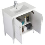The Leafside 30 Inch Bathroom Vanity With Sink showcases a sleek rectangular sink and chrome faucet. Inside its cabinet doors, the shelves hold stacked towels, a decorative box, and two elegant bottles, blending style with functionality.